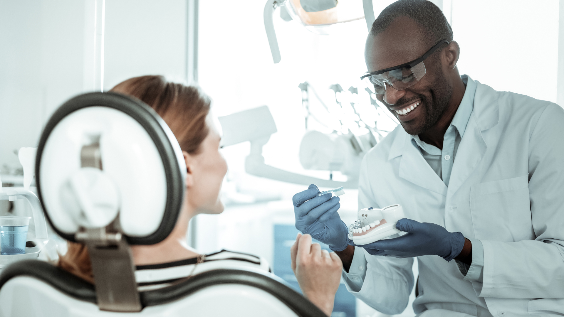Associate dentist showing a patient how to brush.