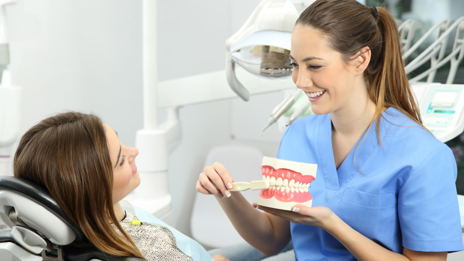 Dental pro showing patient how to brush teeth.